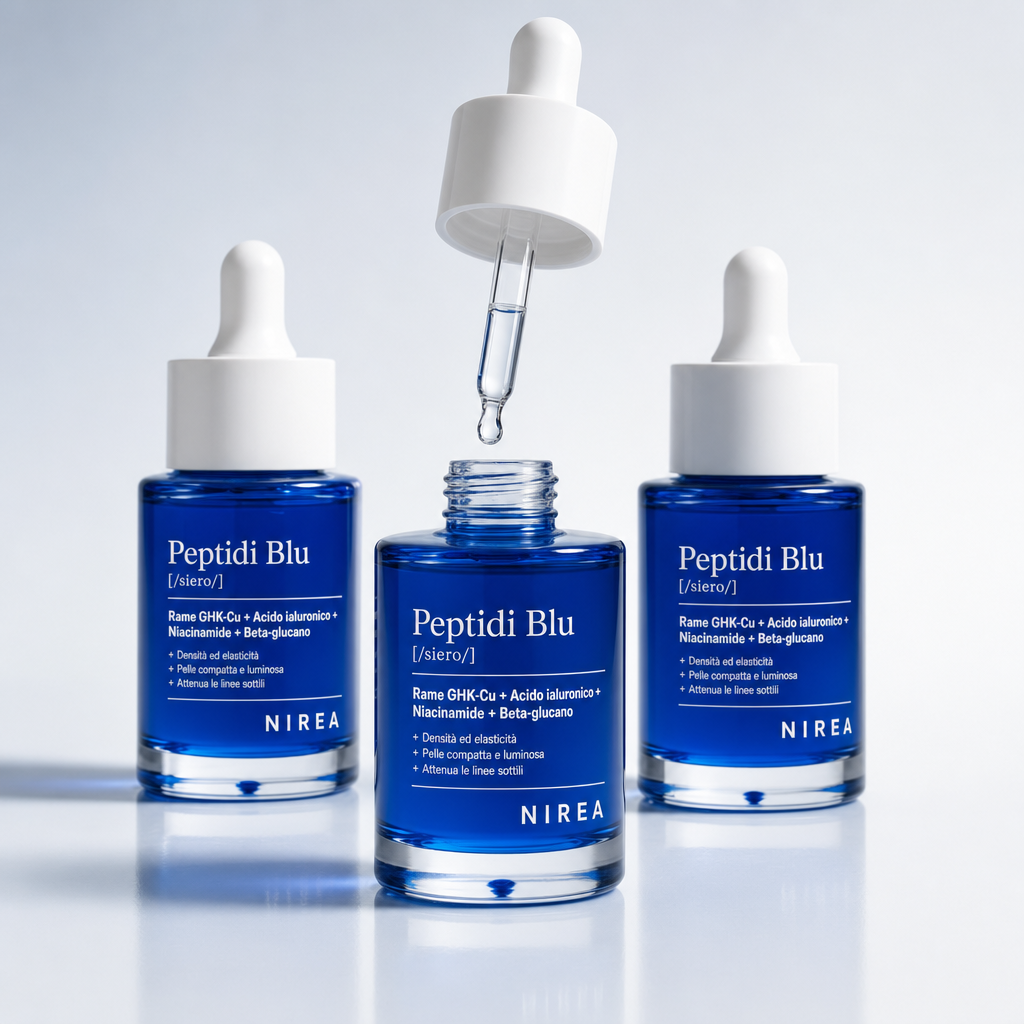Trio di flaconi blu metallizzato del siero su fondale grigio chiaro, uno aperto con contagocce estratto